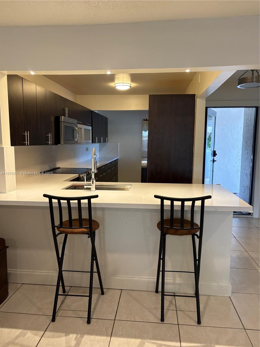 11527 Southwest 84th Lane Miami, FL 33173 - Photo 10 of 17 a kitchen with table chairs and cabinets