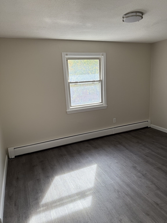 an empty room with wooden floor and a window