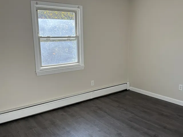 an empty room with wooden floor and a window