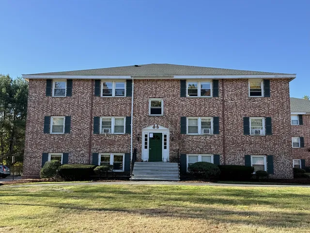a front view of a brick house with a yard