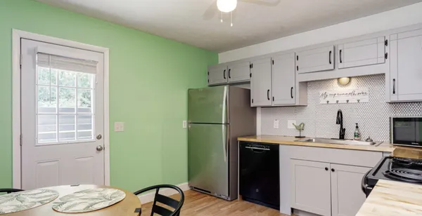 a kitchen with a sink a refrigerator and cabinets