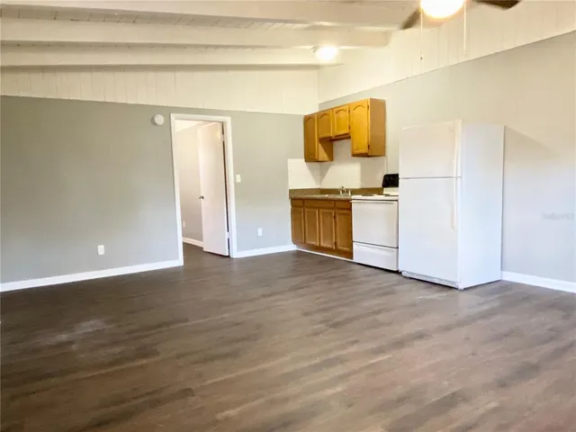 a view of a kitchen with a sink and a refrigerator