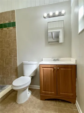 a bathroom with a toilet a sink and mirror