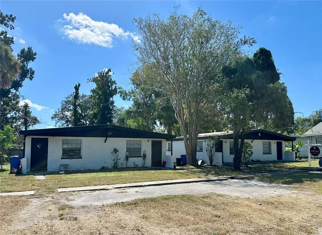 a view of a house with a backyard and a tree