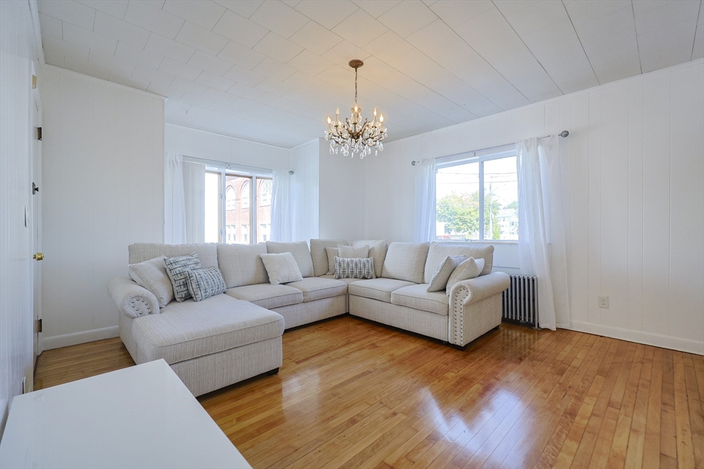 1245 North High Street Fall River, MA 02720 - Photo 13 of 28 a living room with furniture and a chandelier