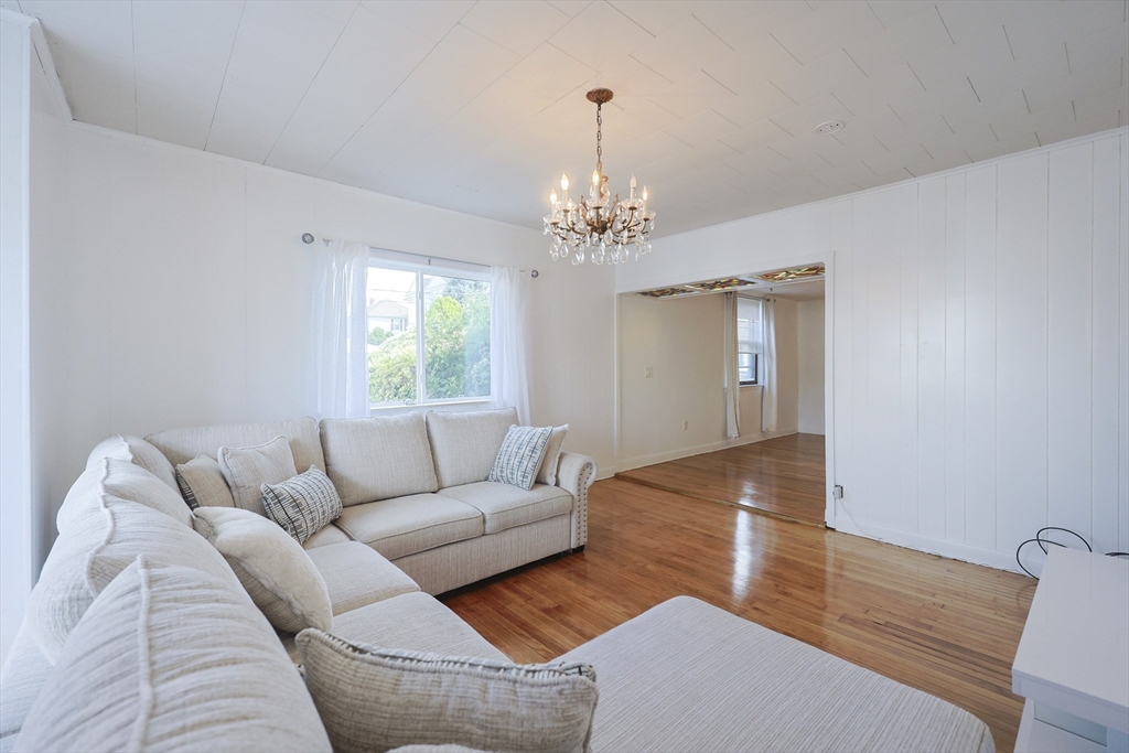 1245 North High Street Fall River, MA 02720 - Photo 15 of 28 a living room with furniture and a chandelier