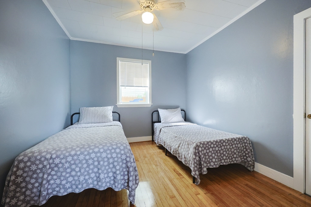 1245 North High Street Fall River, MA 02720 - Photo 27 of 28 a bedroom with a bed and a chandelier