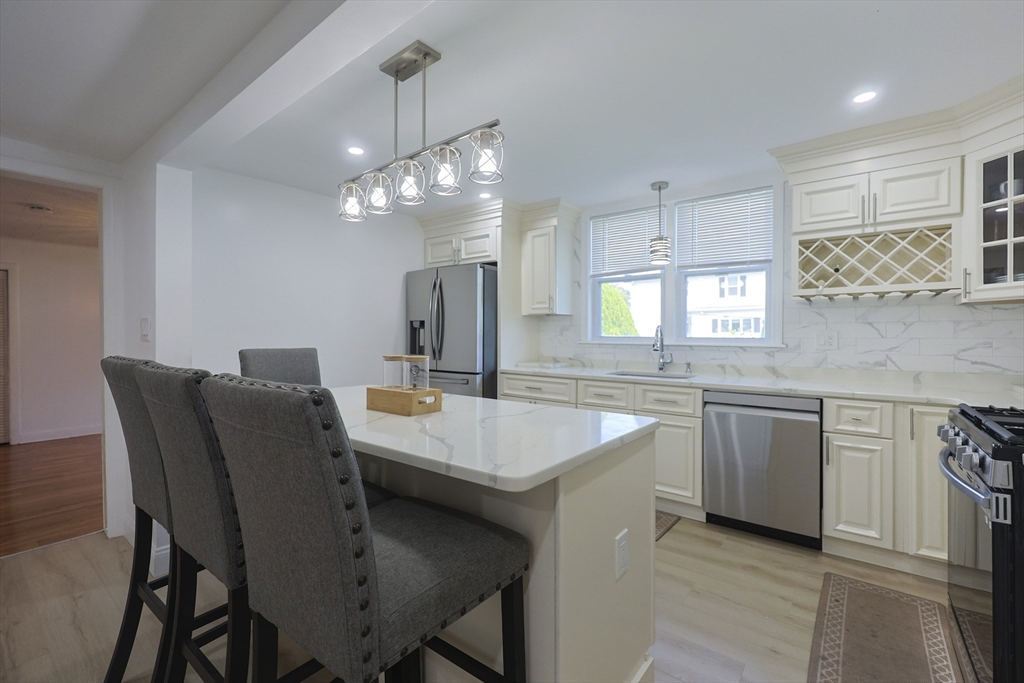 1245 North High Street Fall River, MA 02720 - Photo 8 of 28 a kitchen with a dining table chairs stainless steel appliances and cabinets