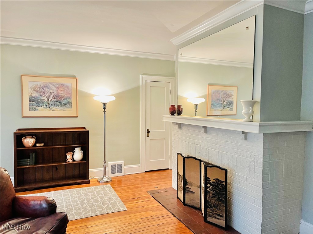 2176 Rexwood Road Cleveland, OH 44118 - Photo 5 of 45 Living room with hardwood / wood-style flooring, ornamental molding, and a brick fireplace