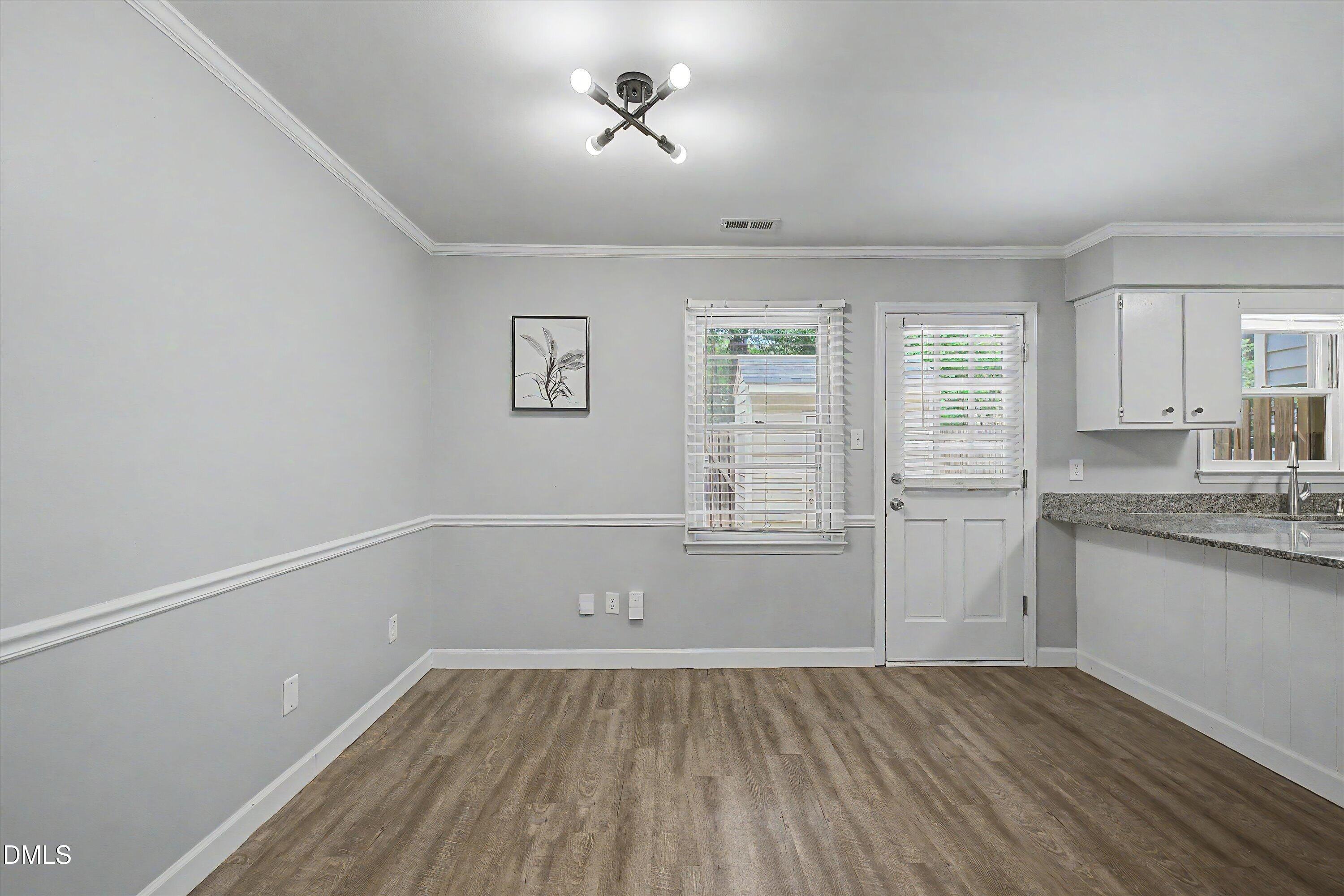5519 Hamstead Crossing Raleigh, NC 27612 - Photo 10 of 33 an empty room with wooden floor and windows