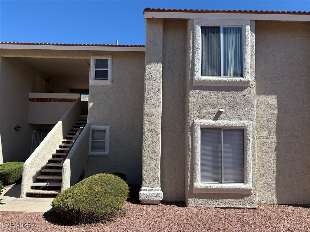 7300 West Pirates Cove Road, Unit 2054 Las Vegas, NV 89145 - Photo 2 of 16 View of side of property featuring stairs and stucco siding