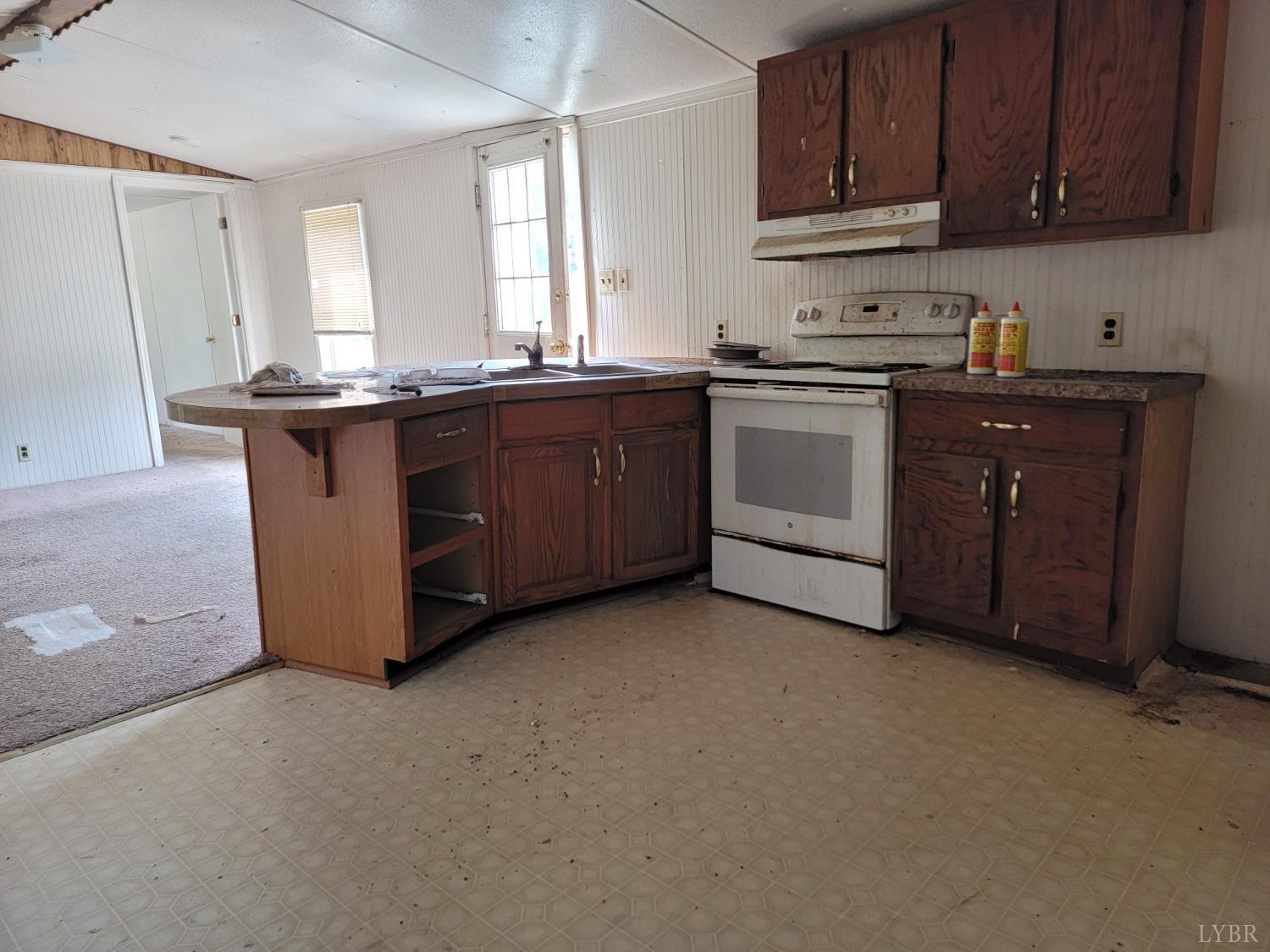 3310 Mountain Road Gretna, VA 24557 - Photo 4 of 15 a kitchen with granite countertop a sink a stove and cabinets
