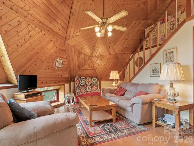 a living room with furniture a flat screen tv and a chandelier