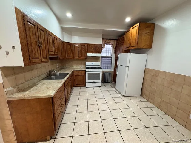 a kitchen with a sink a stove top oven and cabinets