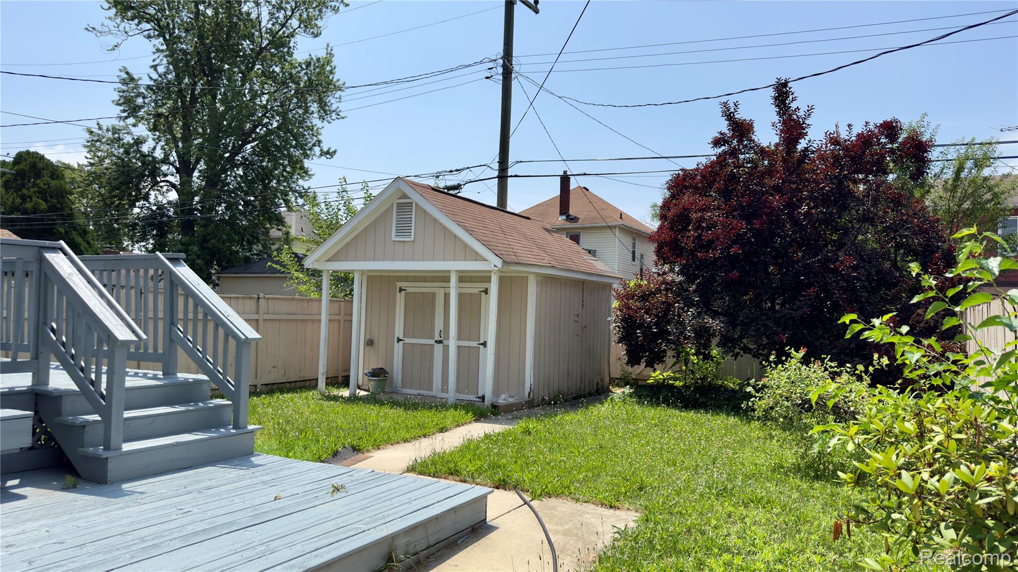 130 Elm Street River Rouge, MI 48218 - Photo 5 of 20 Expansive backyard featuring a multi-level wooden deck, concrete pathway, and a detached shed with a gabled roof