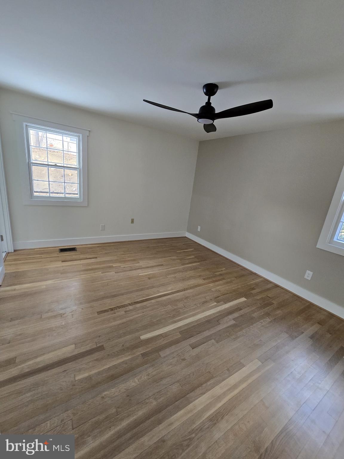 1014 Nora Drive Silver Spring, MD 20904 - Photo 17 of 23 an empty room with wooden floor ceiling fan and windows