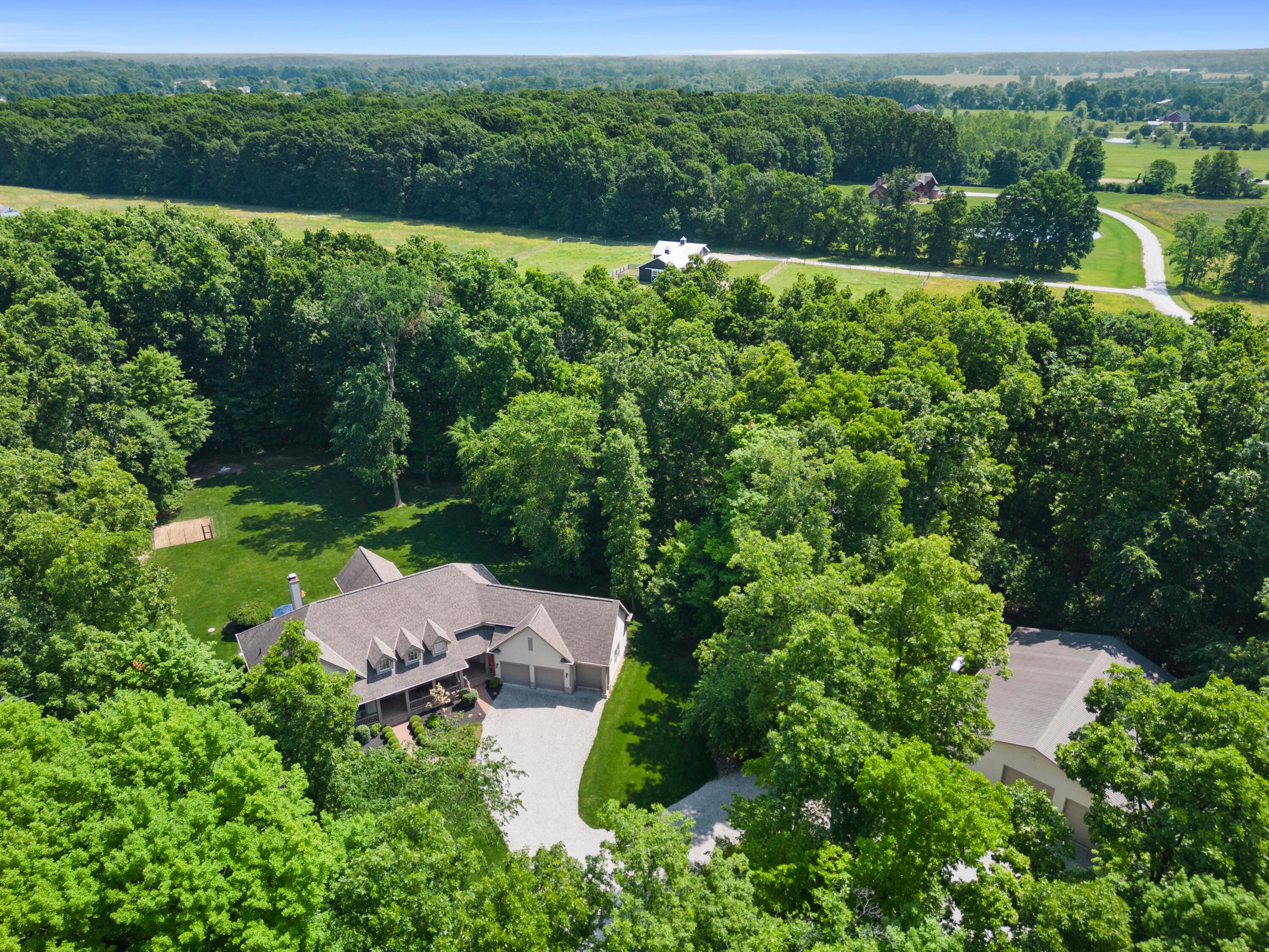 5761 Hughes Road Galena, OH 43021 - Photo 3 of 43 Wonderful curb appeal with stone accented exterior & water table, Hardie Plank siding, covered front Porch with brick flooring & recessed lighting; Extensive landscaping all around adds to the natural beauty of the property.