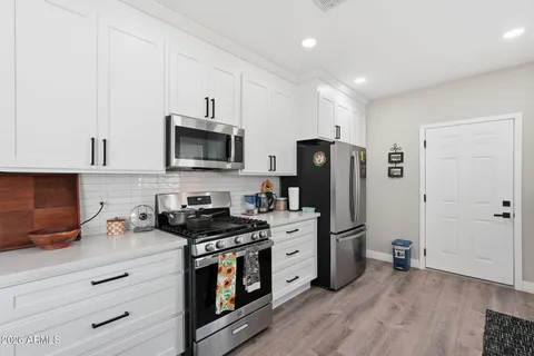 a kitchen with stainless steel appliances a stove microwave and refrigerator