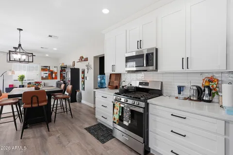 a kitchen with stainless steel appliances a stove a sink a microwave and cabinets
