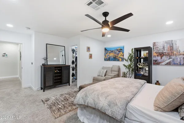 a bedroom with a large bed and a chandelier
