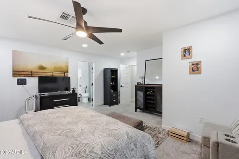 a large bedroom with a bed and a flat screen tv