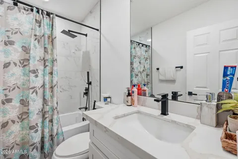 a bathroom with a sink toilet vanity and shower