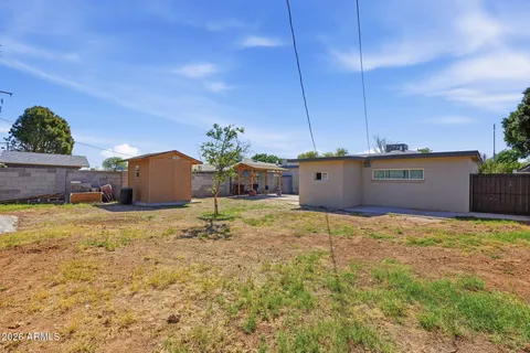 a view of a house with backyard and sitting area