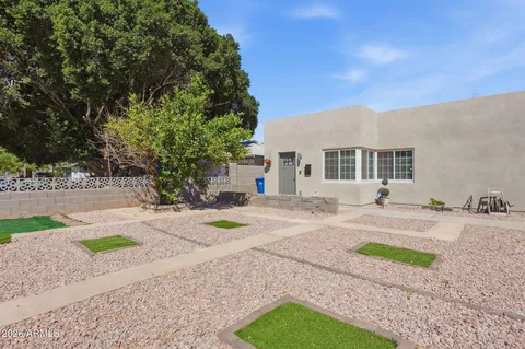 a front view of a house with a yard and trees