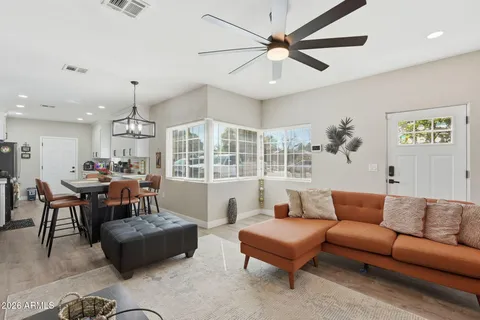 a living room with furniture kitchen view and a chandelier