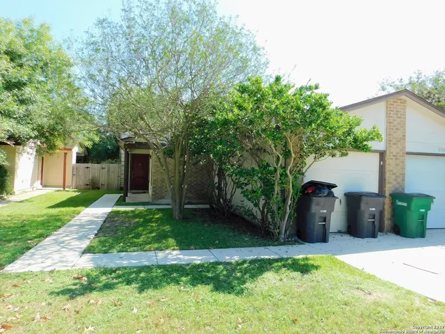 a view of a house with backyard and a tree