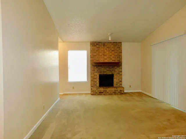 a view of empty room with a fireplace