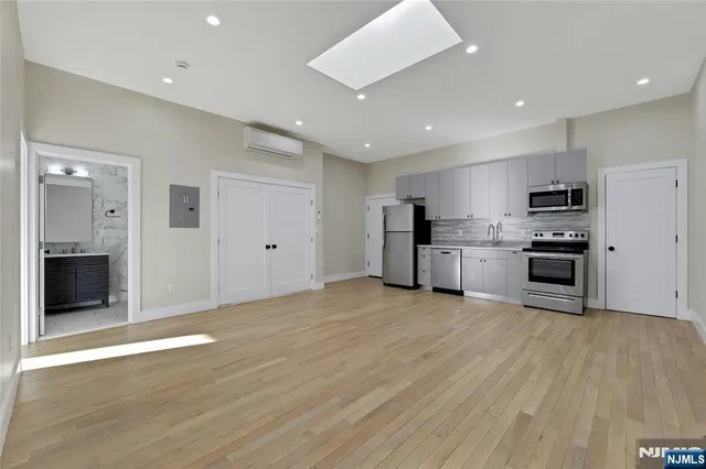 a view of a kitchen with refrigerator stove and wooden cabinets