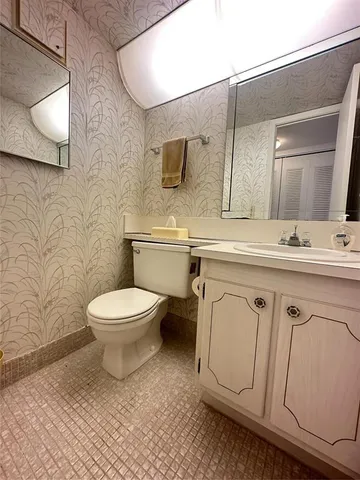 a white toilet sitting next to a bathroom sink