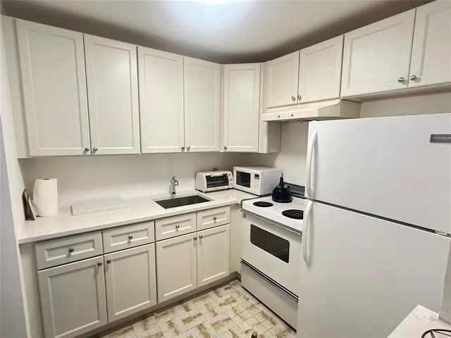 a kitchen with cabinets and white appliances