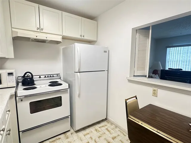 a kitchen with stainless steel appliances a stove a refrigerator and cabinets