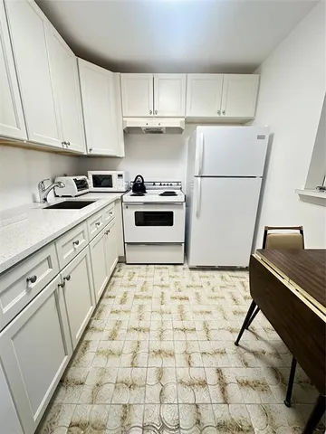 a living room with furniture a flat screen tv and a stove