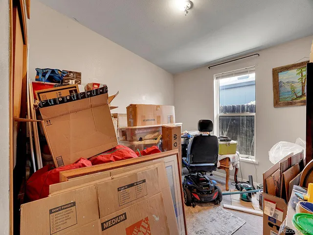 a bedroom with bed and a painting on the wall