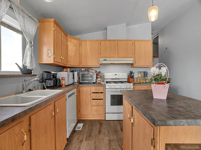 a kitchen with granite countertop a sink appliances cabinets and counter space