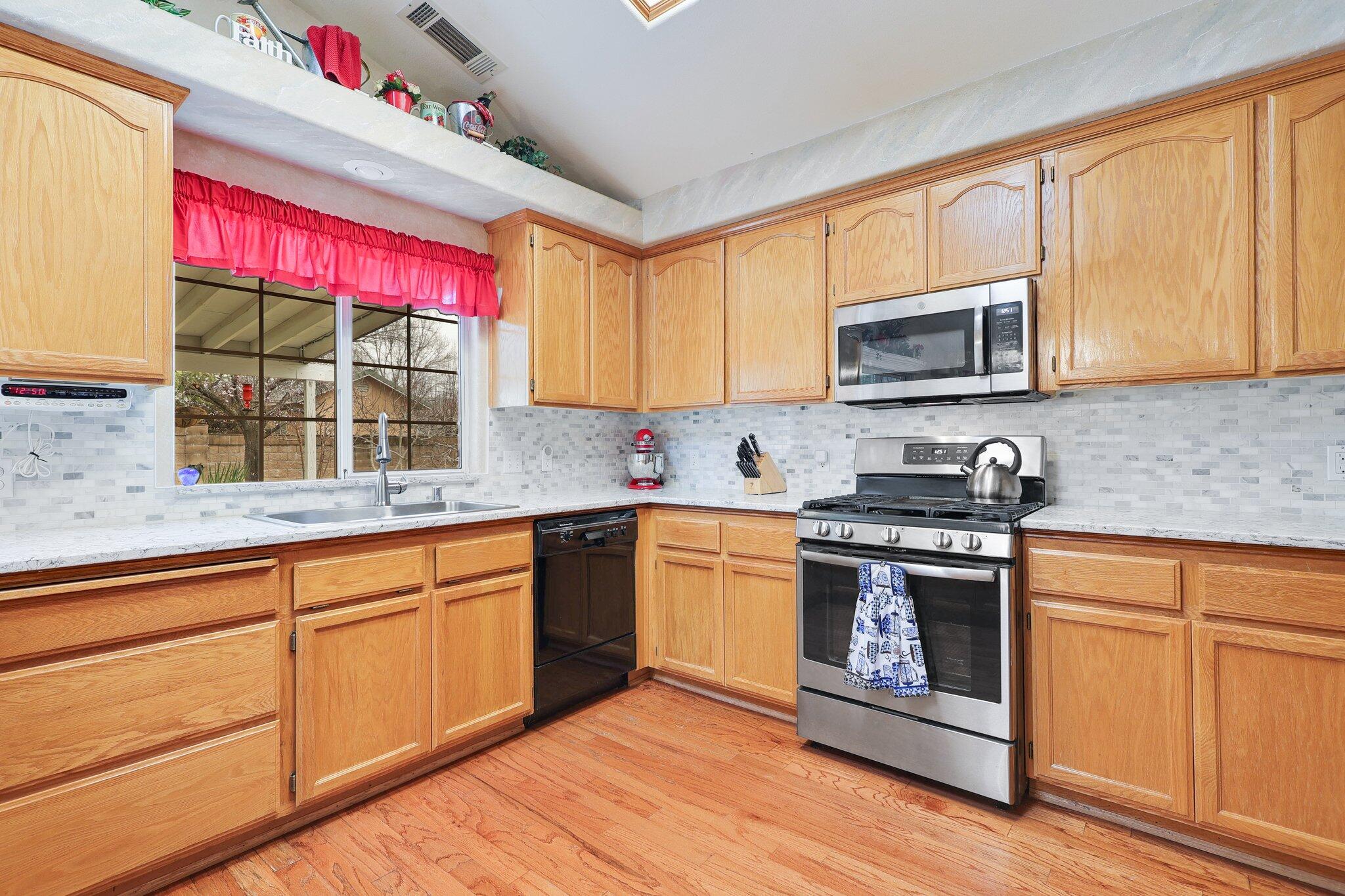 19271 Lexington Lane Redding, CA 96003 - Photo 11 of 39 a kitchen with stainless steel appliances granite countertop a stove sink microwave and window