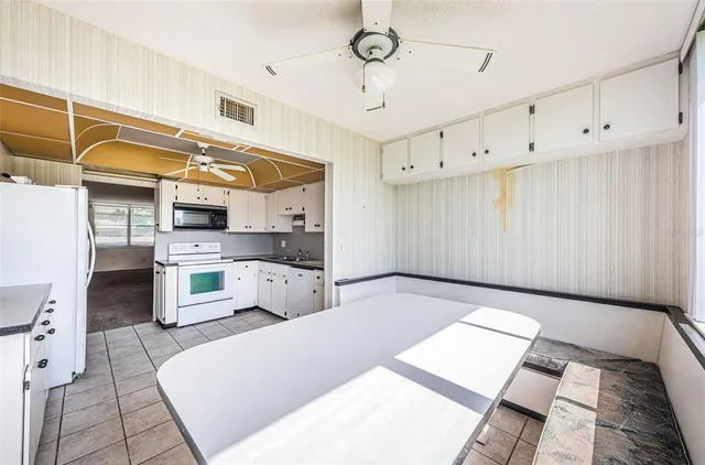 a large white kitchen with cabinets