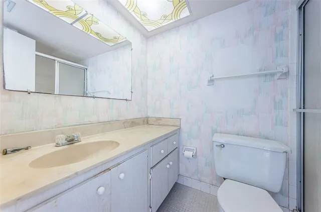 a bathroom with a granite countertop toilet sink and mirror