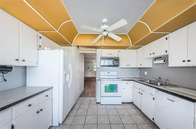 a kitchen with a sink a stove cabinets and a window