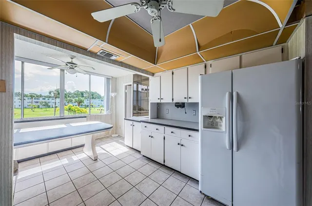 a kitchen with granite countertop a sink and refrigerator