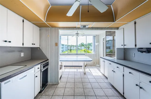 a kitchen with a sink a stove and white cabinets