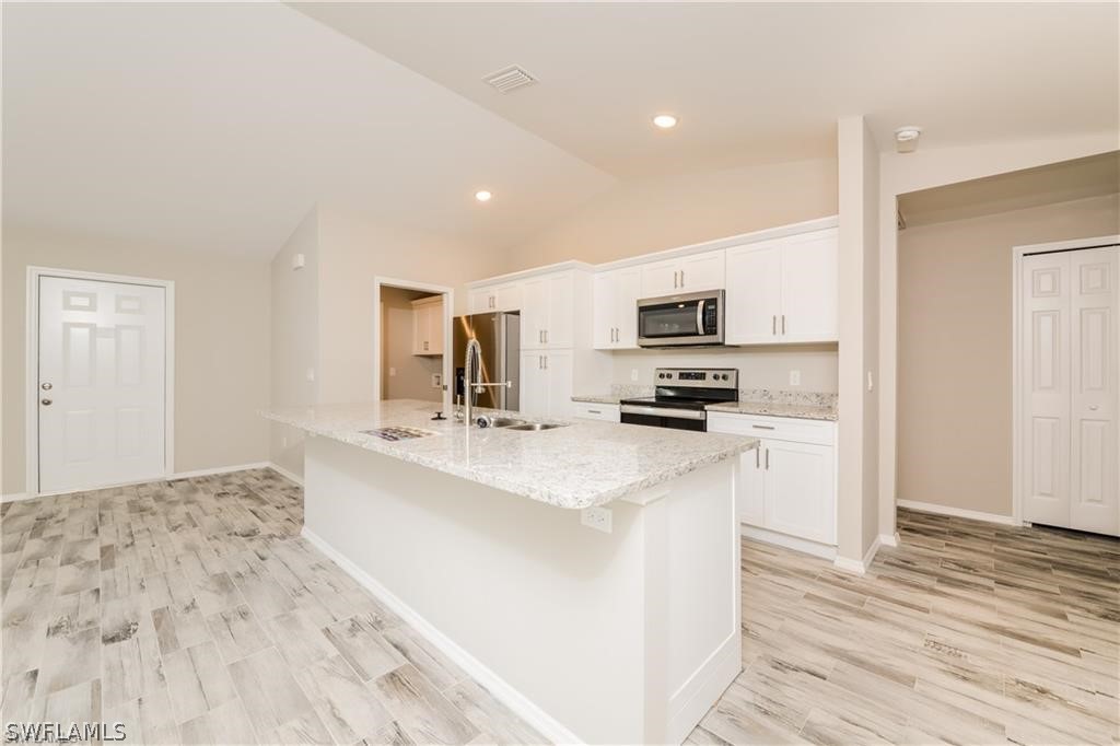 8422 Cardinal Road Fort Myers, FL 33967 - Photo 5 of 15 a kitchen with stainless steel appliances a sink and a refrigerator