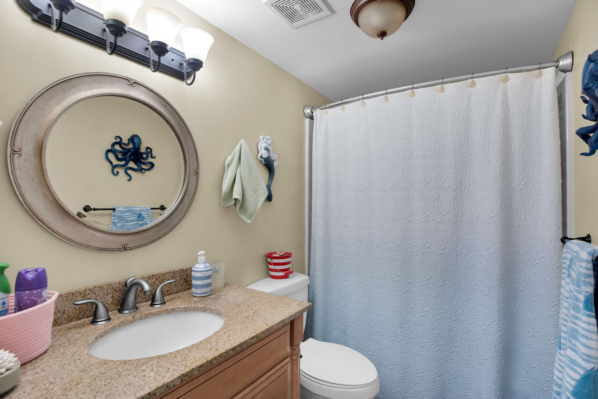 1041 Gibraltar Road Key Largo, FL 33037 - Photo 17 of 36 a bathroom with a granite countertop sink vanity mirror and toilet