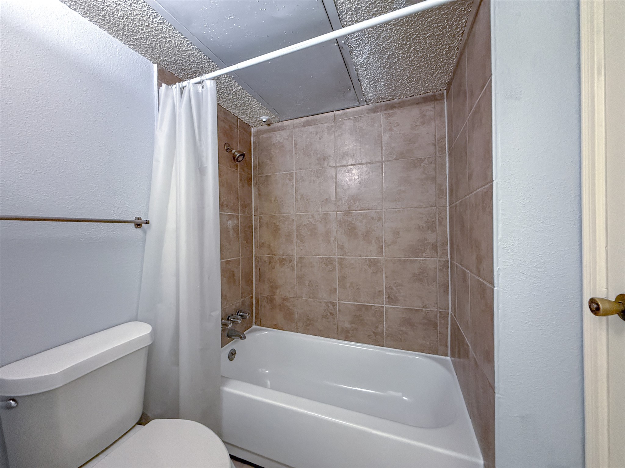 3100 Jeanetta Street, Unit 1104 Houston, TX 77063 - Photo 12 of 19 a white toilet sitting next to a bath tub