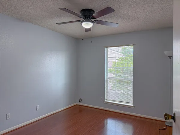 an empty room with a window and a fan