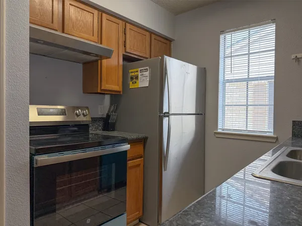 a kitchen with stainless steel appliances granite countertop a refrigerator and a sink
