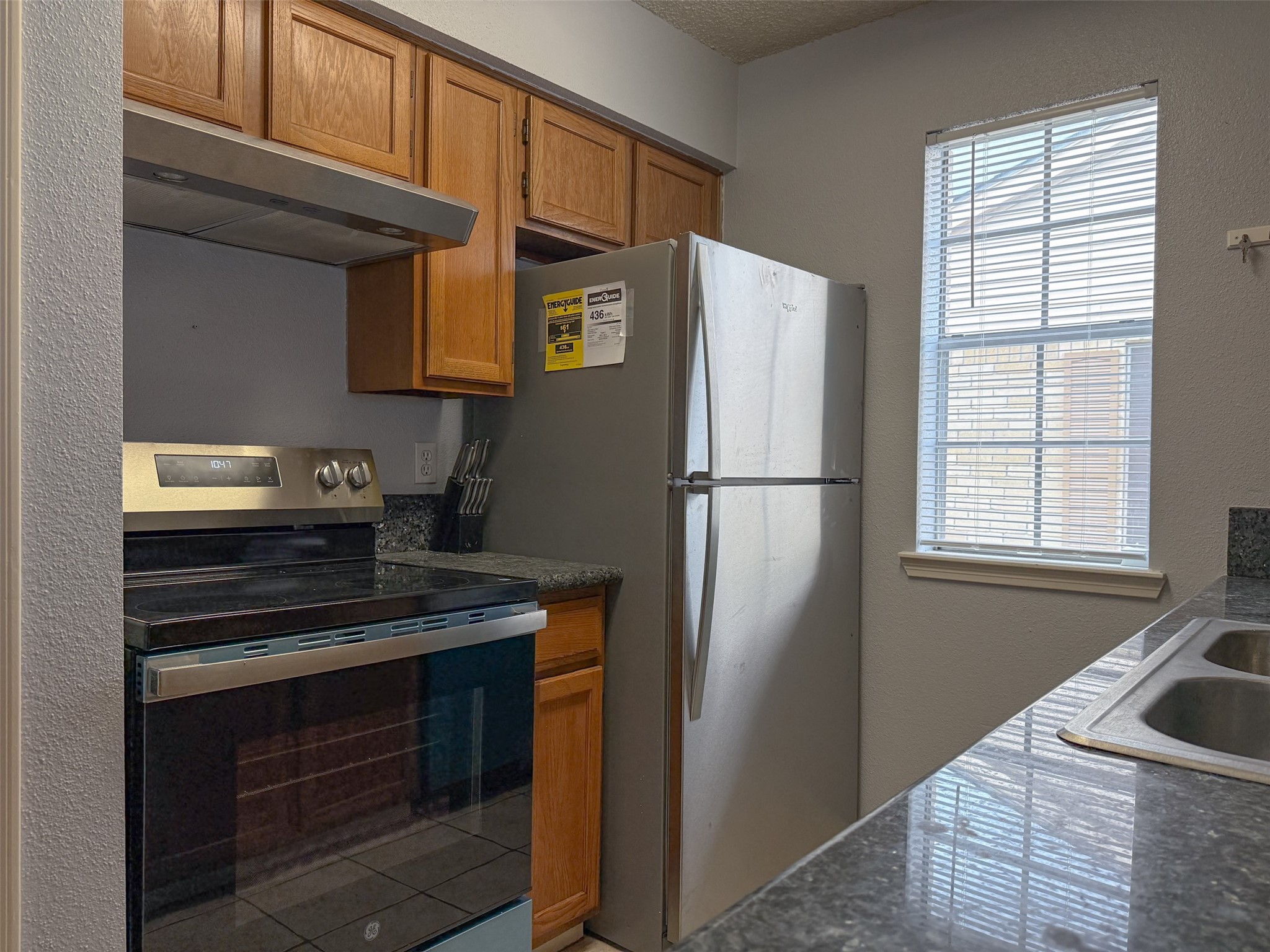 3100 Jeanetta Street, Unit 1104 Houston, TX 77063 - Photo 4 of 19 a kitchen with stainless steel appliances granite countertop a refrigerator and a sink